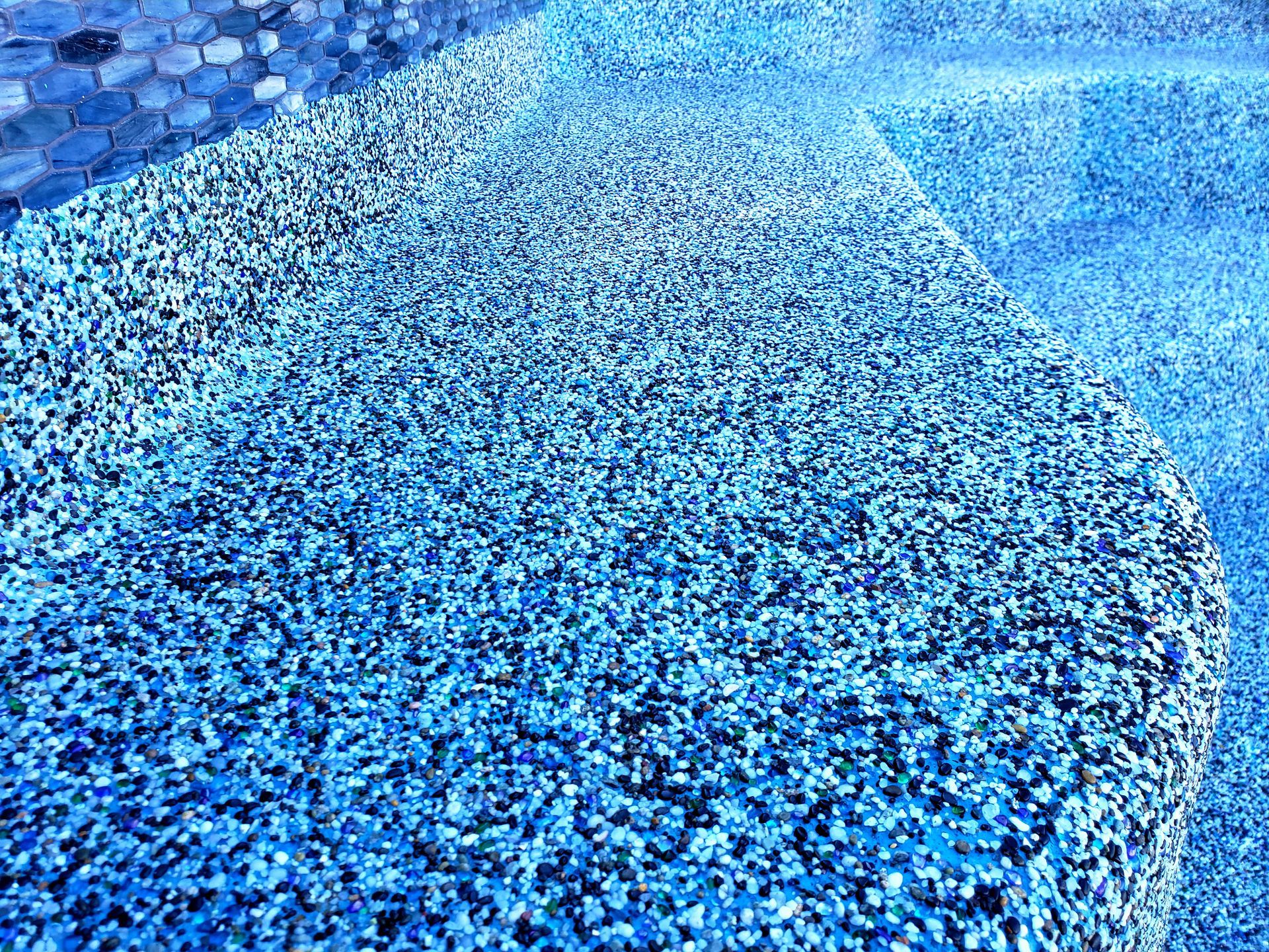 A pile of blue gravel is sitting on top of a pool.