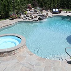 A large swimming pool with a hot tub in the middle of it.