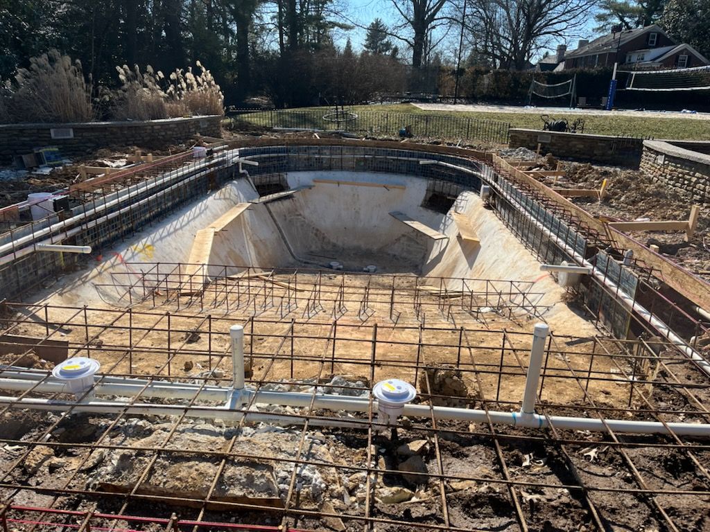A swimming pool is being built in the backyard of a house.
