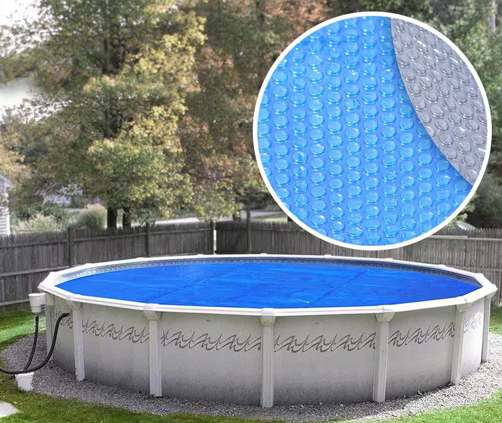 A swimming pool with a blue solar blanket on top of it.