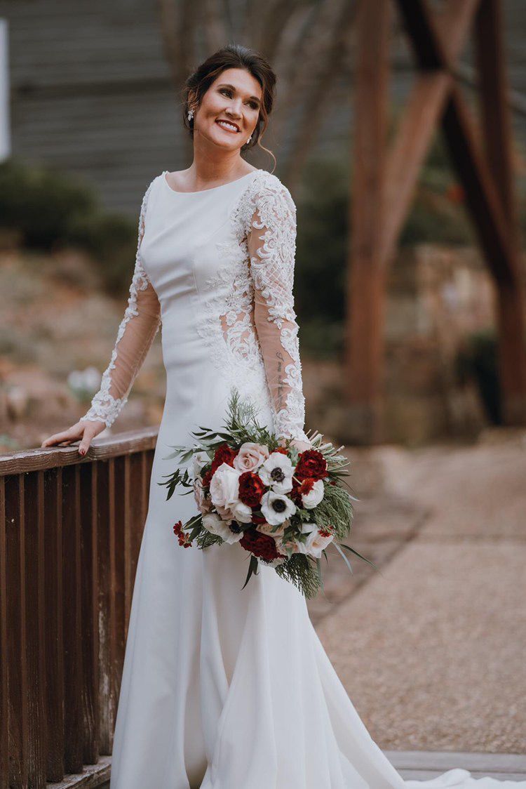 The bride is wearing a white wedding dress and holding a bouquet of flowers.