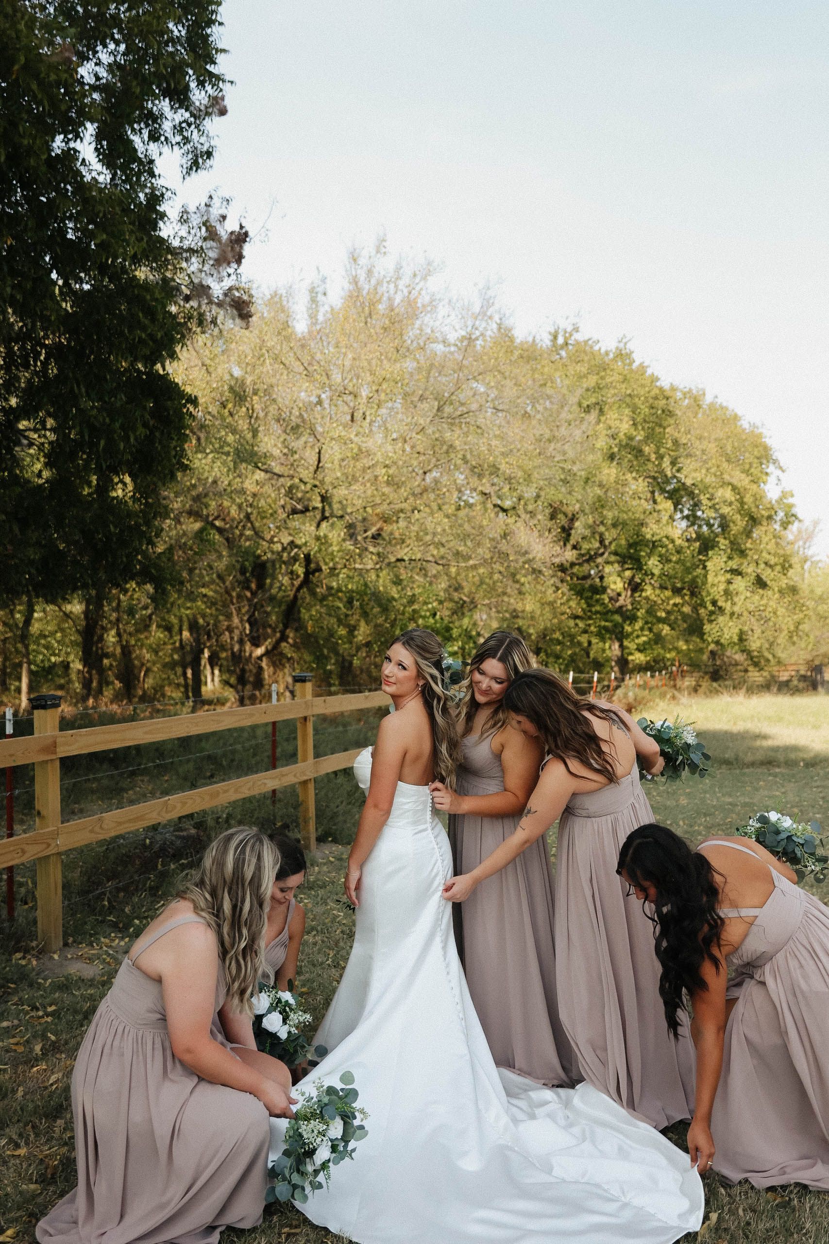 A bride and her bridesmaids are helping the bride get ready for her wedding.