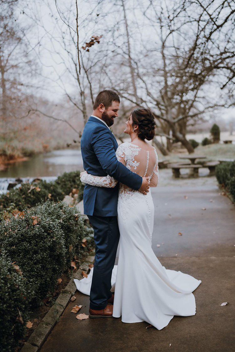 A bride and groom are hugging each other on their wedding day.