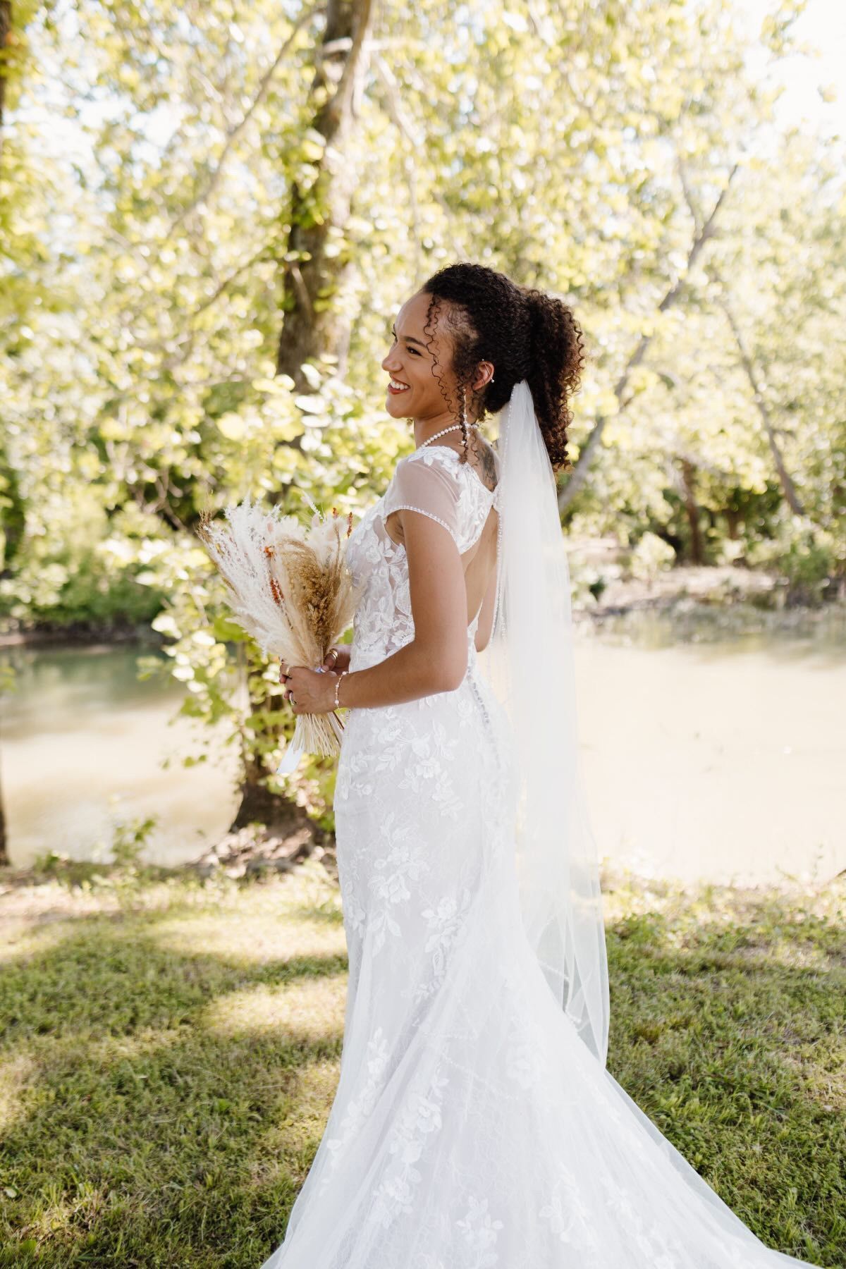 A bride in a wedding dress and veil is holding a bouquet of flowers.