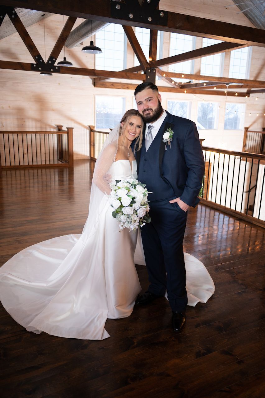 A bride and groom are posing for a picture in a room.