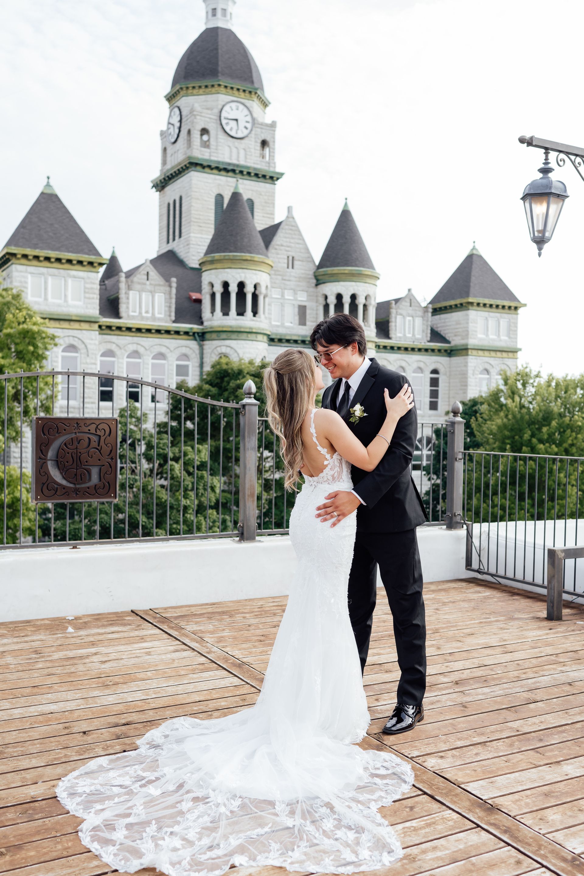 A bride and groom are kissing in front of a castle.