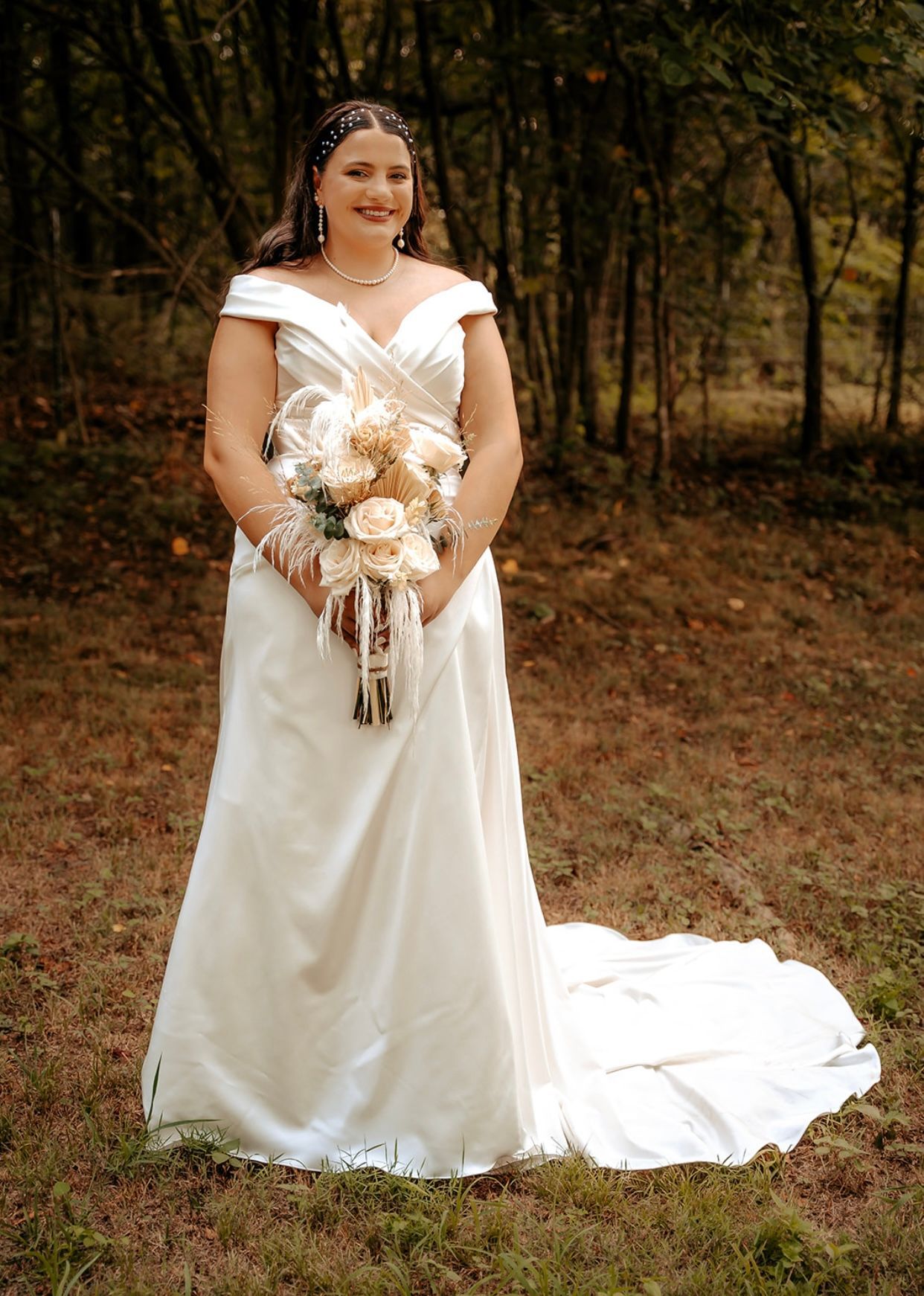 The bride is wearing a white wedding dress and holding a bouquet of flowers.