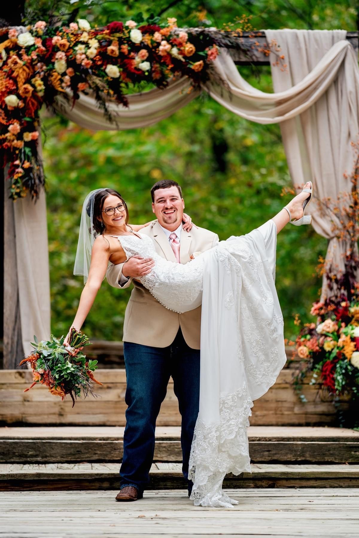 A bride and groom are posing for a picture at their wedding ceremony.