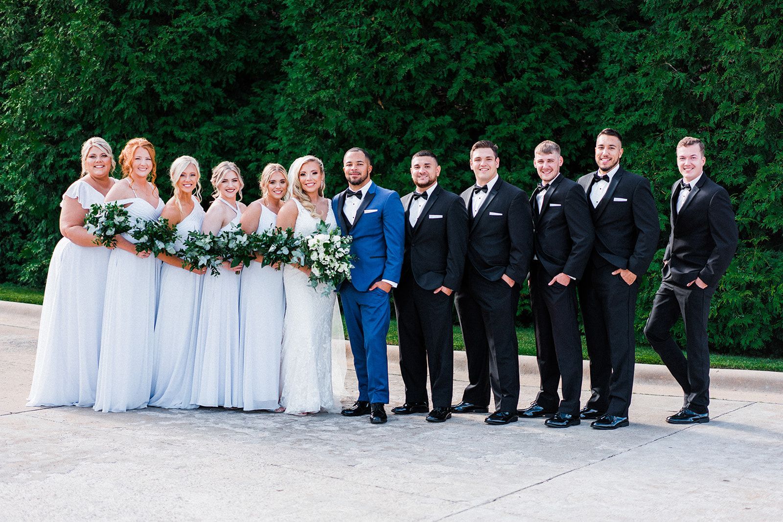 The bride and groom are posing for a picture with their wedding party.