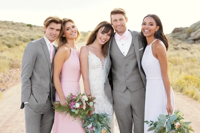 A group of people standing next to each other on a dirt road.