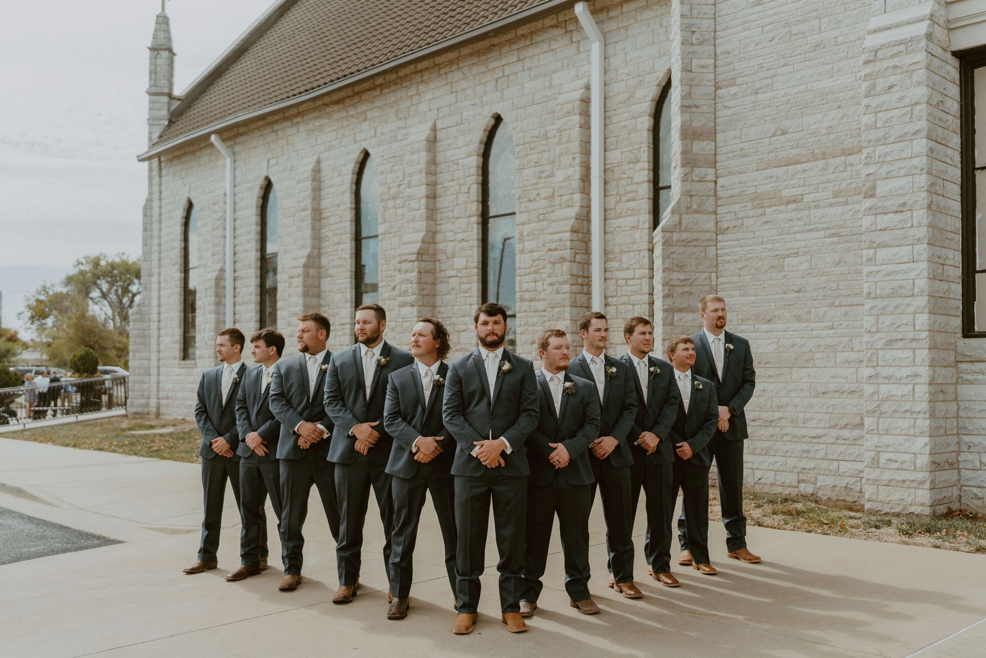 The groom and his groomsmen are standing in front of a church.