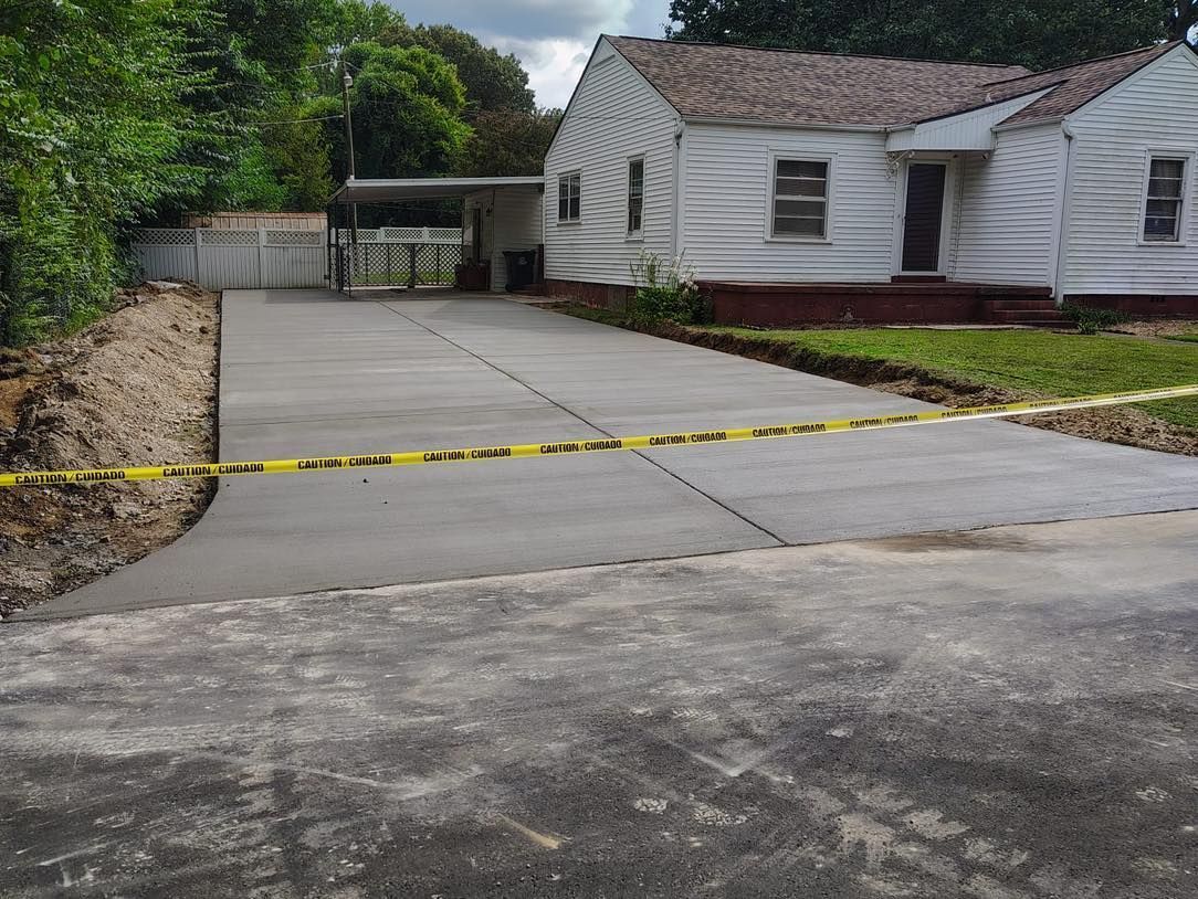 New concrete driveway blocked by yellow caution tape beside a white house