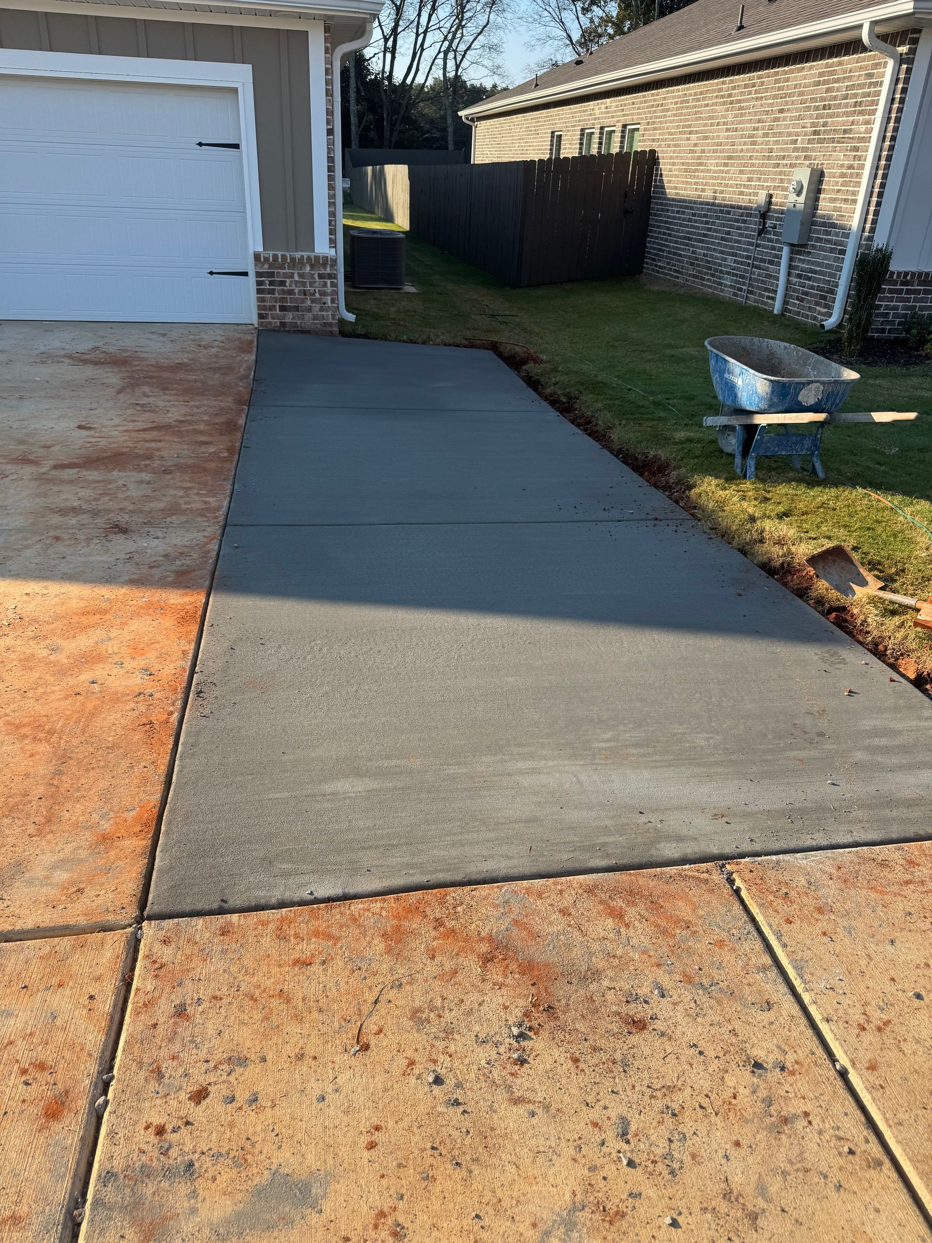 Rock-lined drainage culvert opening in a landscaped yard with gravel paths and grass
