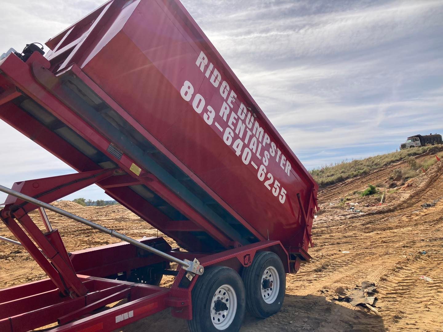 A red dumpster that says ridge dumpster on it