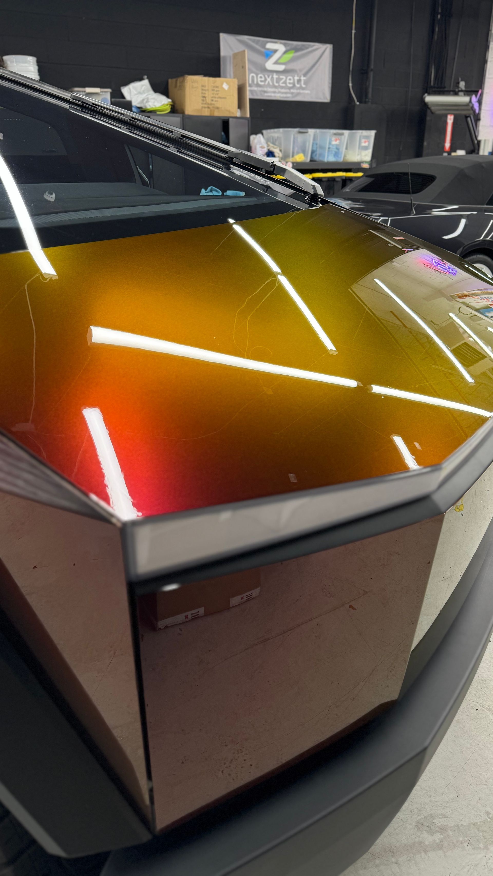 A close up of a car 's hood in a garage.