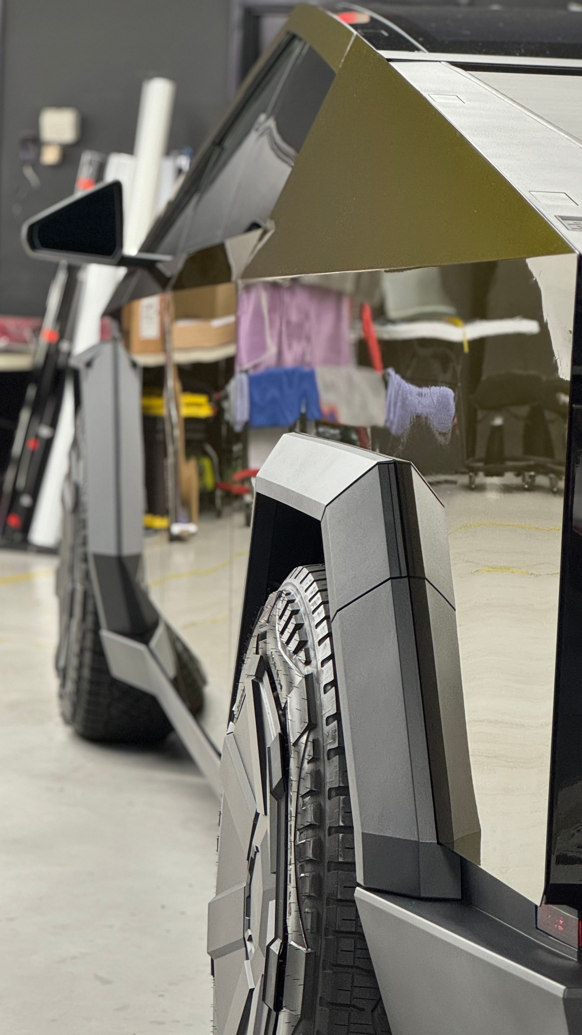 A cardboard model of a tesla model s is sitting in a garage.