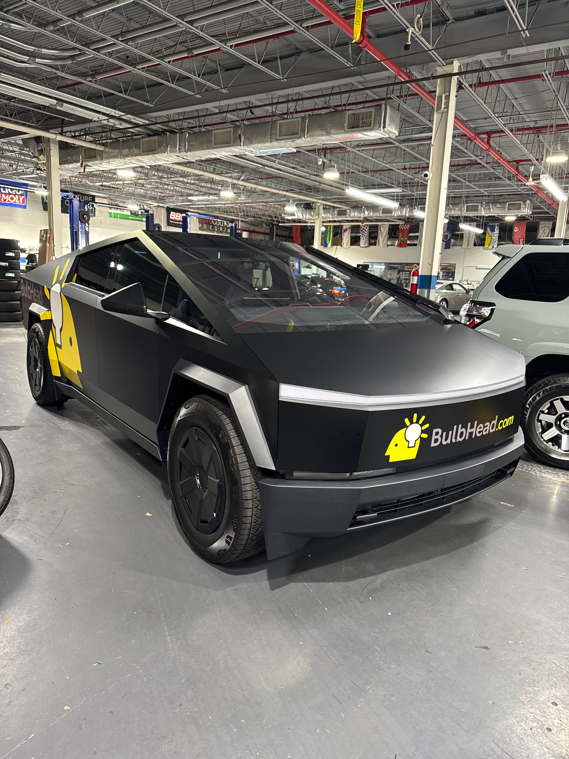 A black tesla model s is parked in a garage.