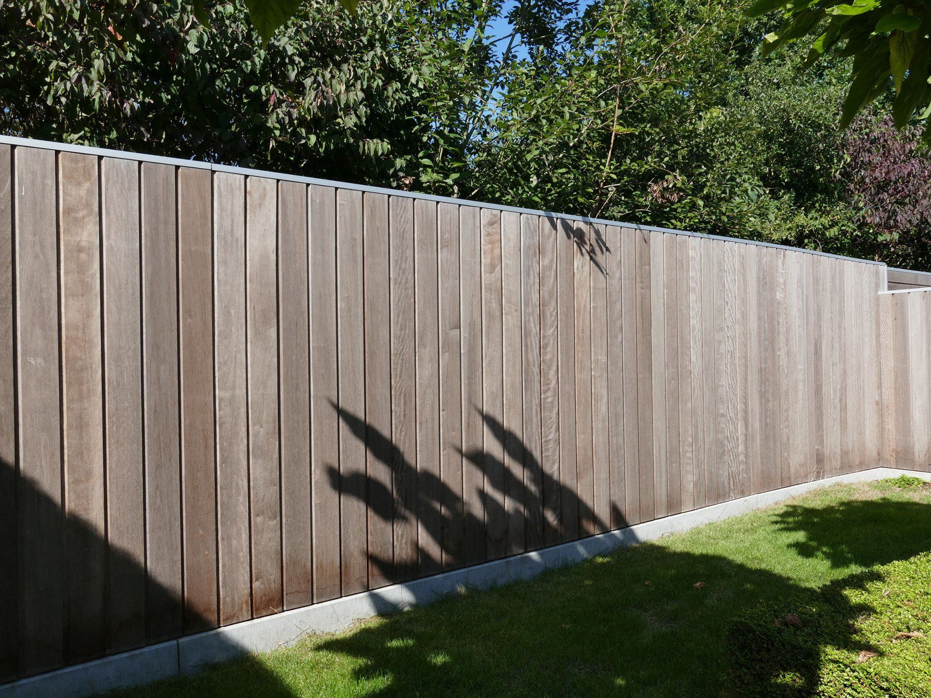 Houten afsluiting met onzichtbare aluminium palen