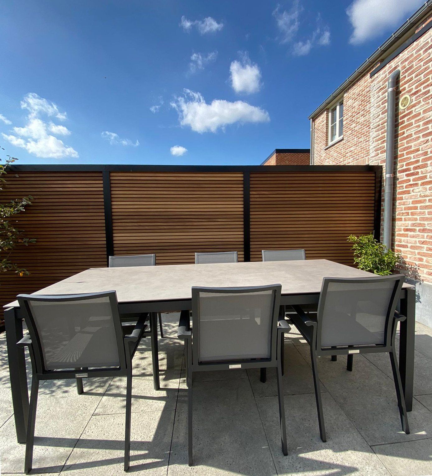 Houten afsluiting met zichtbare zwarte aluminium palen