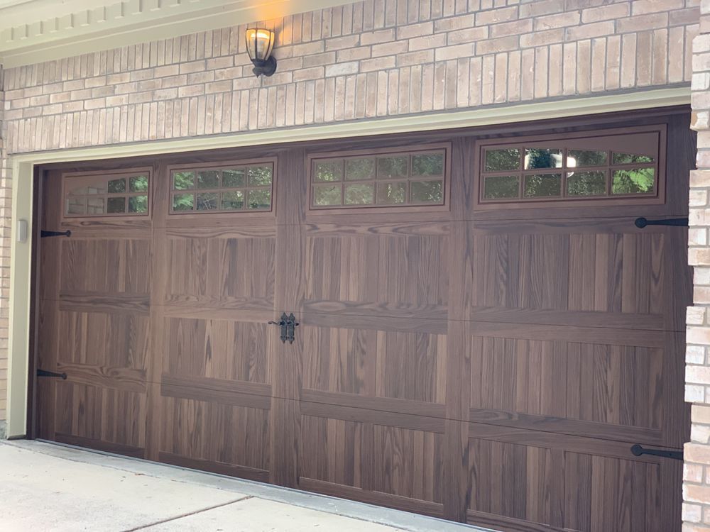 A large wooden garage door is sitting on top of a brick building.