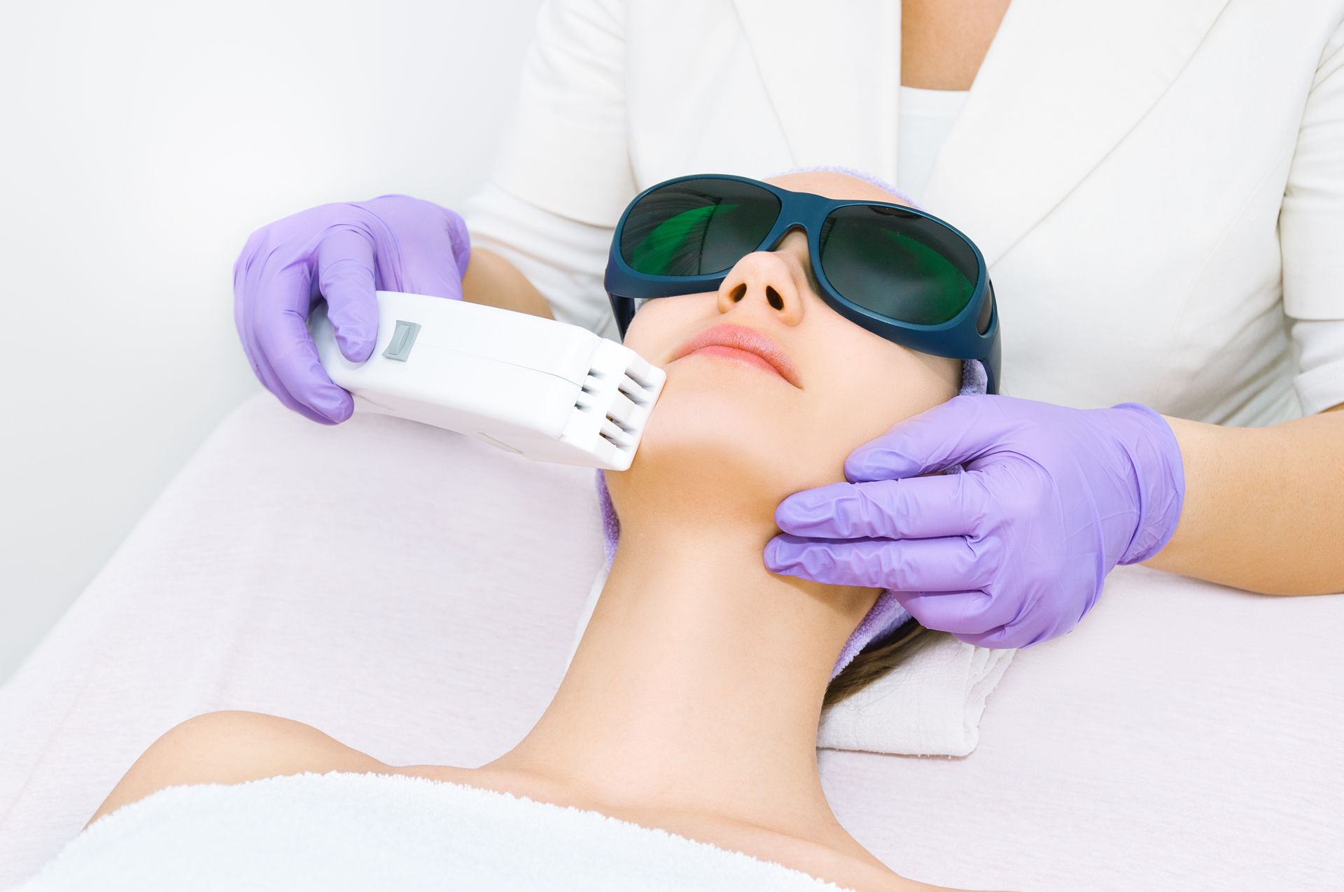 A woman is receiving a laser treatment at a medspa for glowing, youthful skin.