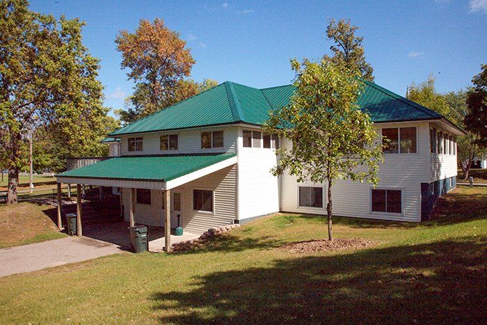 a white house with a green roof and a porch