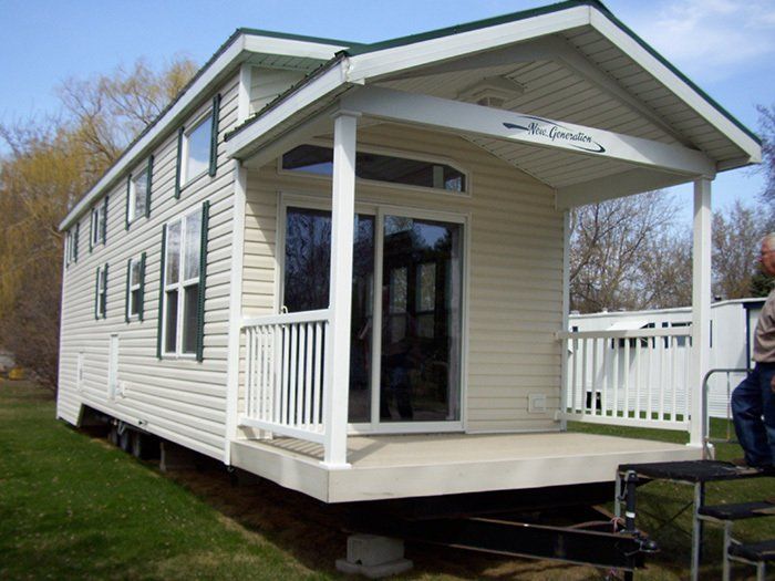 a man is standing in front of a small house with a porch