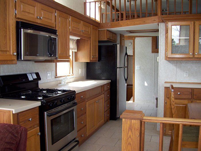 a kitchen with wooden cabinets and a black refrigerator