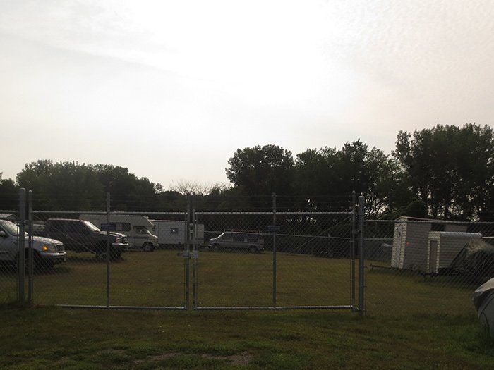 a fenced in area with a lot of cars parked in it