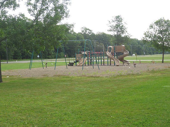a playground with swings and a slide in a park