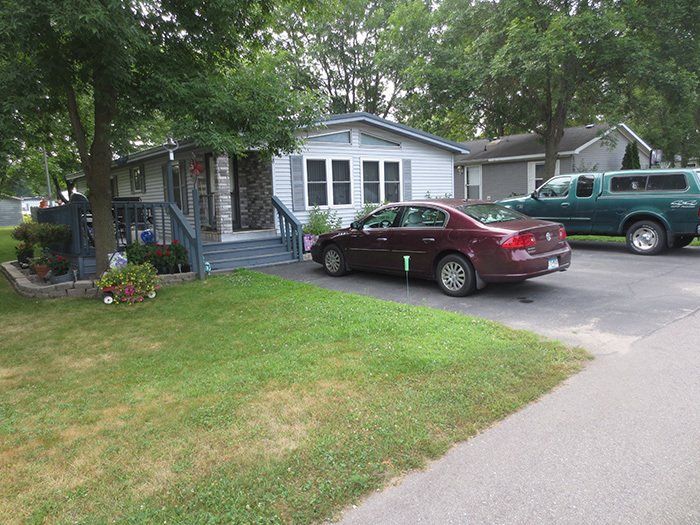 a red car is parked in front of a mobile home .