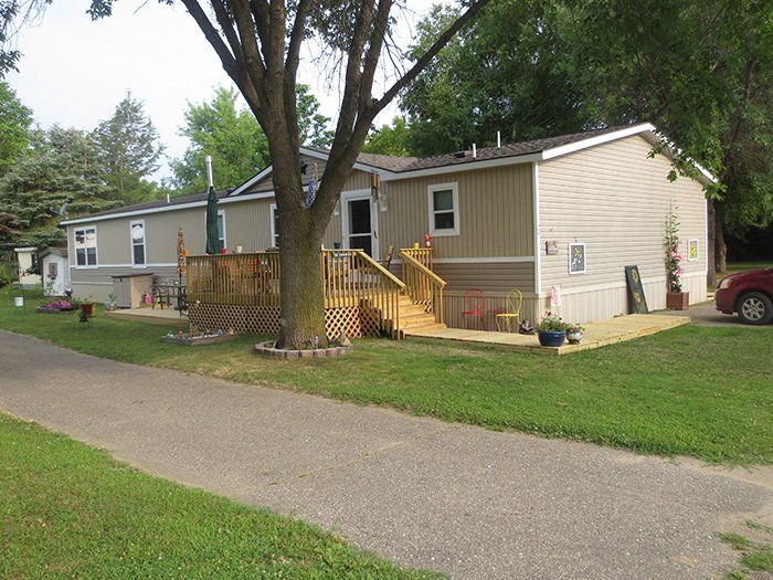 a mobile home with a red car parked in front of it .