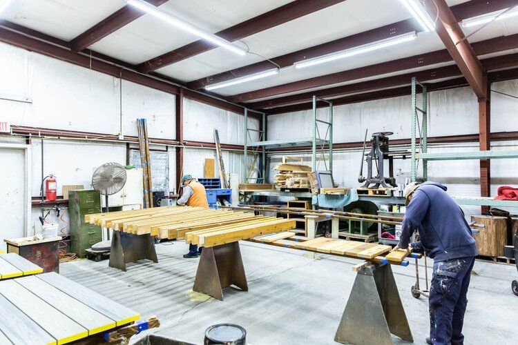 A man is working on a piece of wood in a factory.