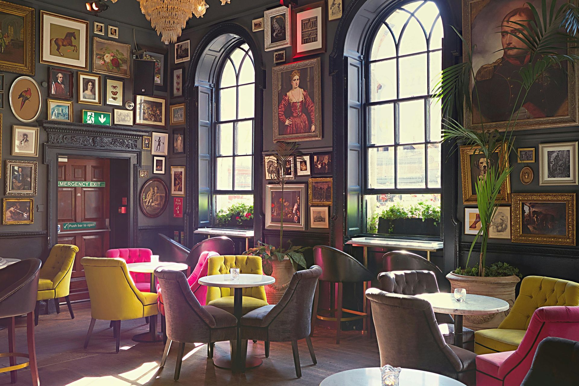 A restaurant with tables and chairs and paintings on the wall.