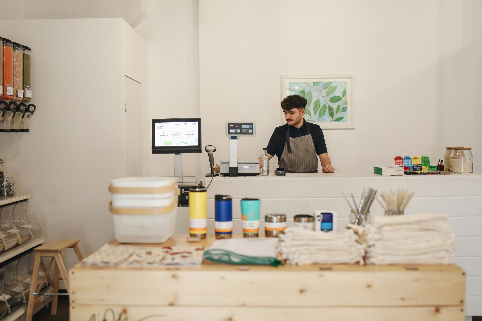 A man is standing behind a counter in a store.