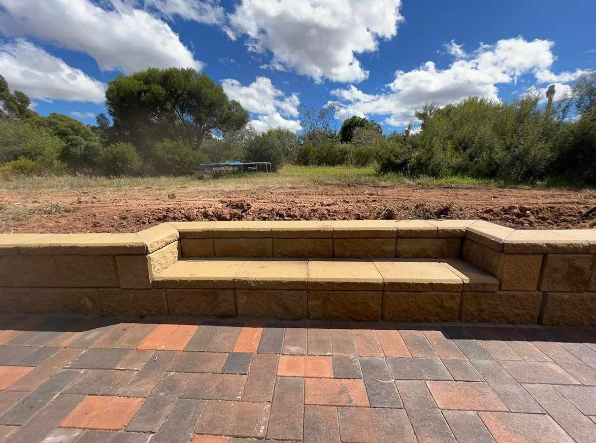 A Brick Wall With Steps Leading to a Field With Trees in the Background — B & C Yard Improvements in Dubbo, NSW