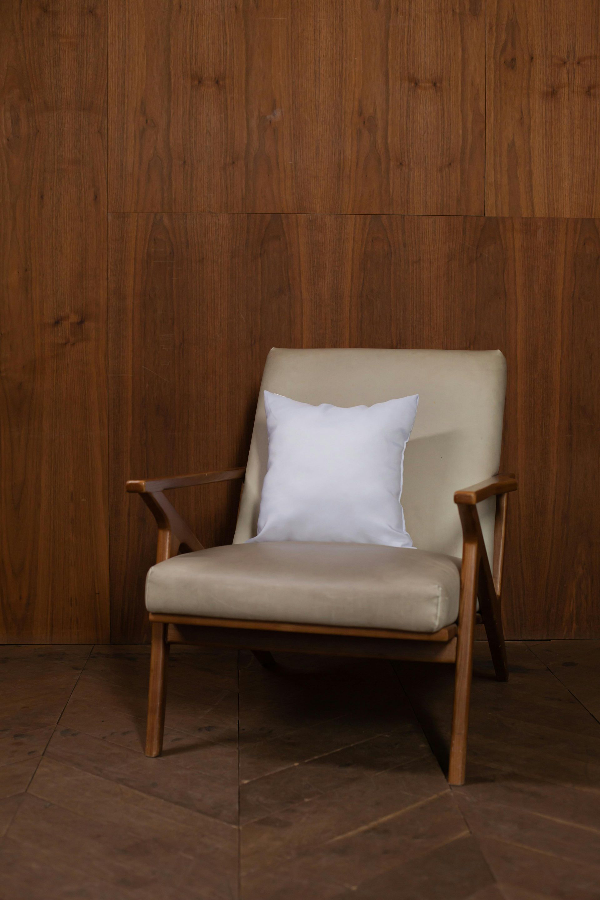 Chair with white cushion in front of wooden wall.