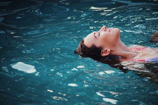 Acercamiento a cara de mujer flotando en una piscina