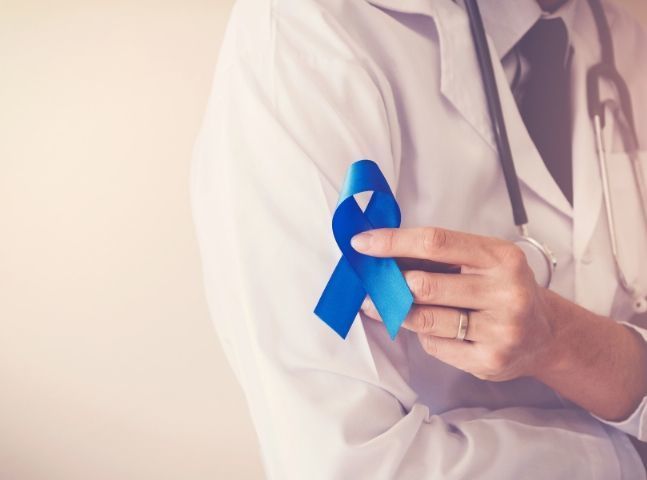 Médica con cinta en la mano con símbolo del cáncer