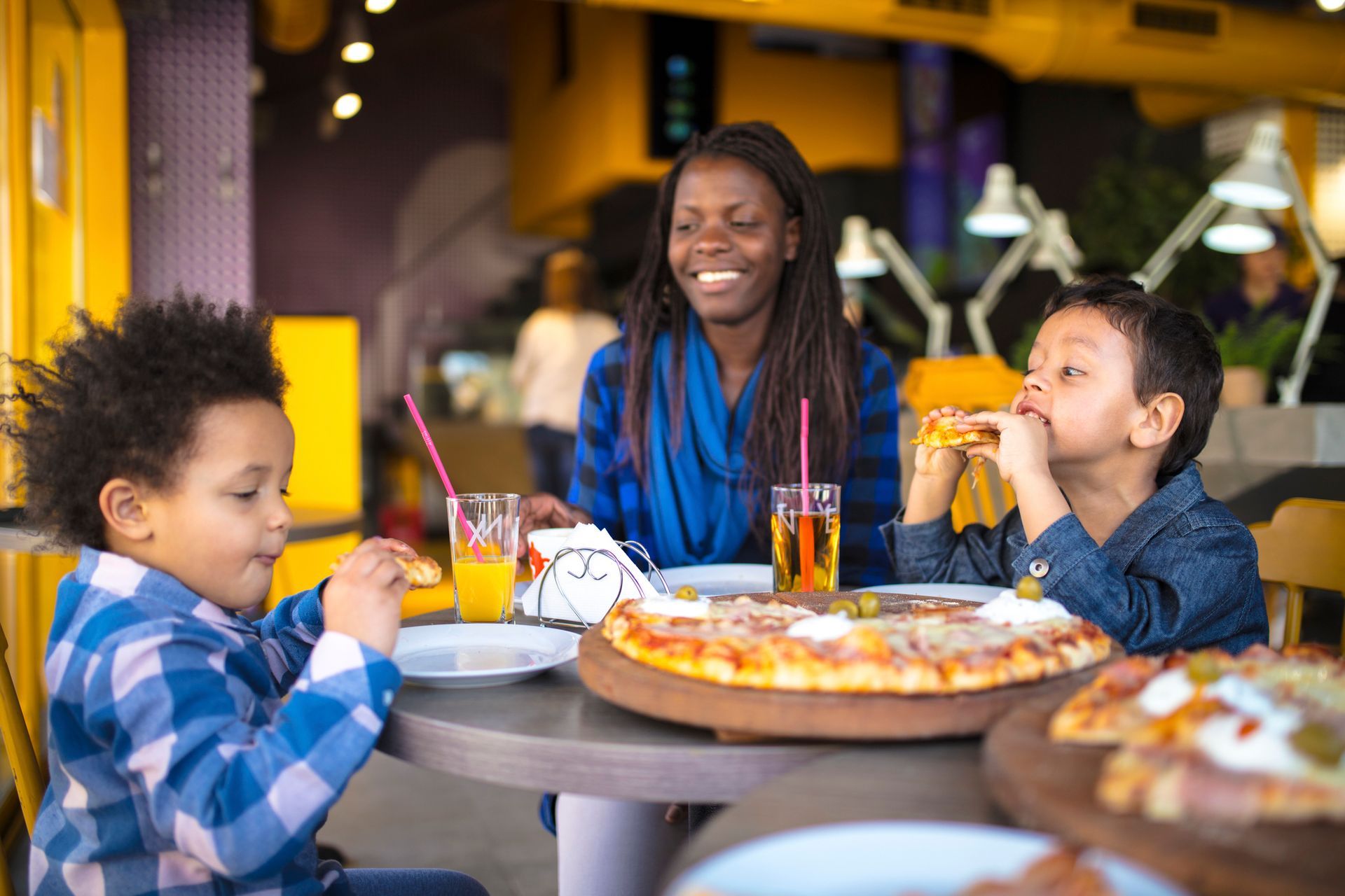 Mother and children eating pizza Mother and children eating pizza