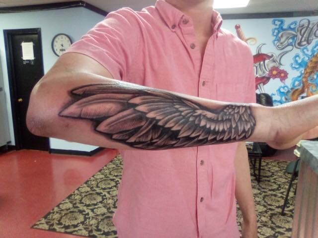 man with wing tattoo on arm