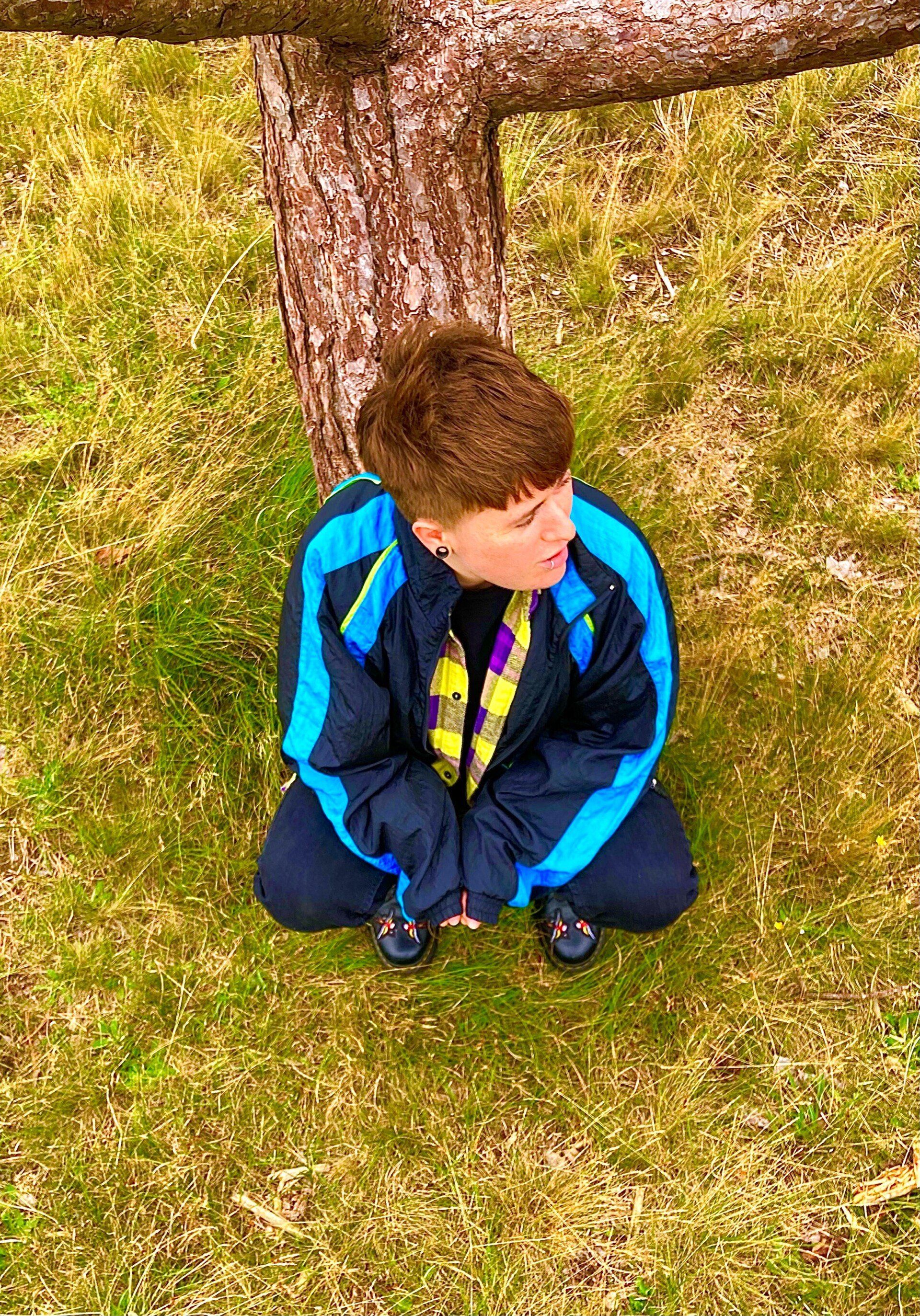 Person sitting in front of tree