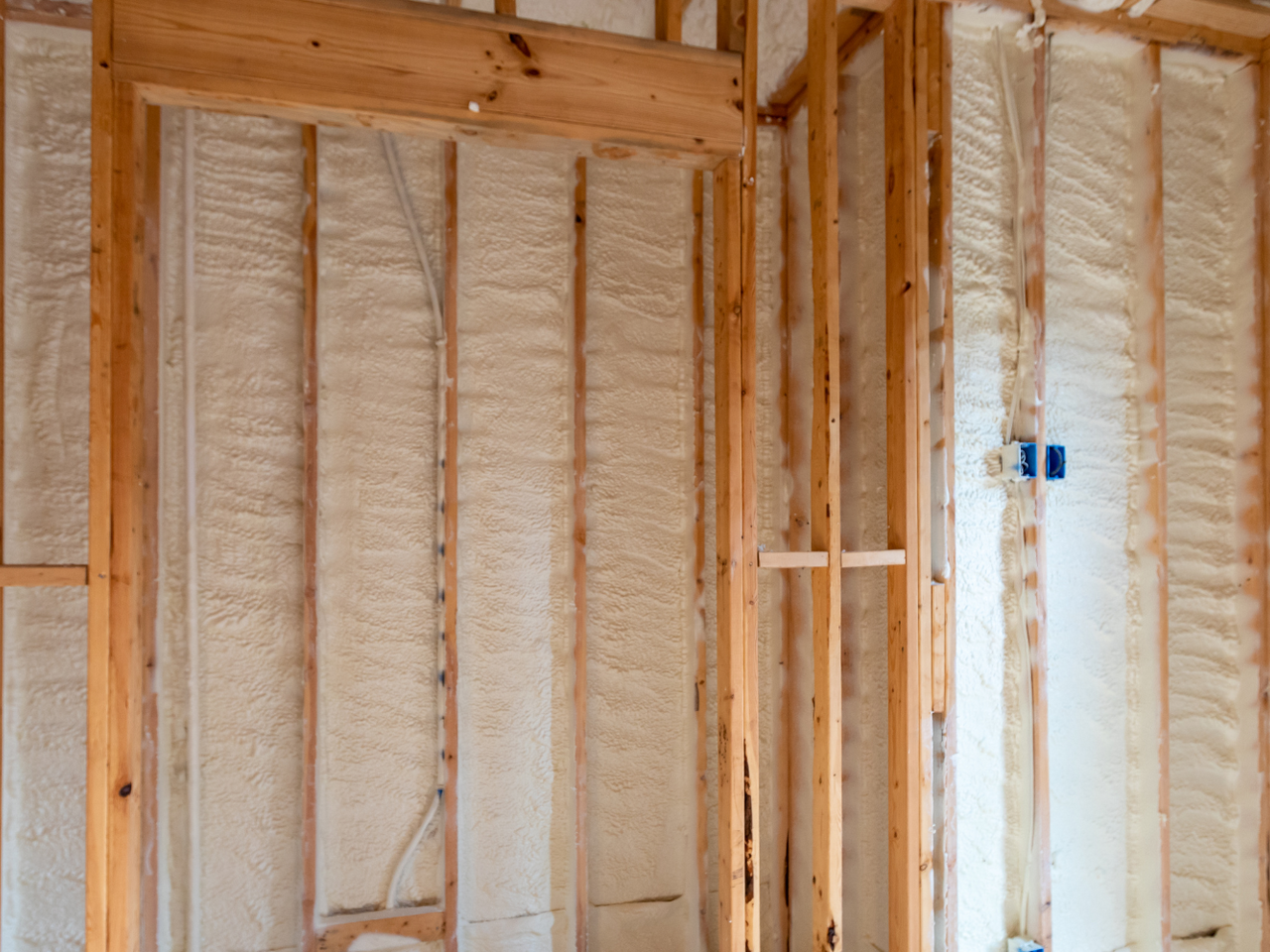 A room with wooden beams and foam insulation on the walls.