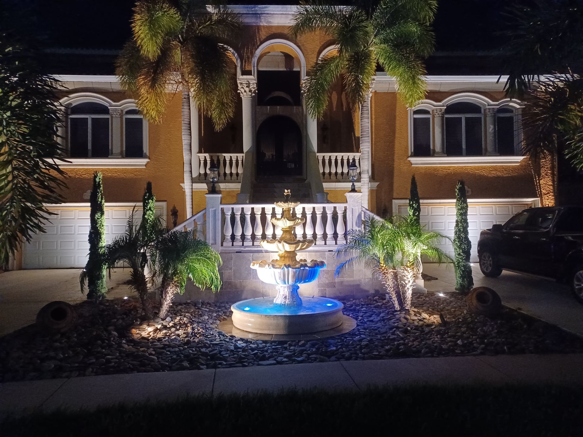 A house with a fountain in front of it at night
