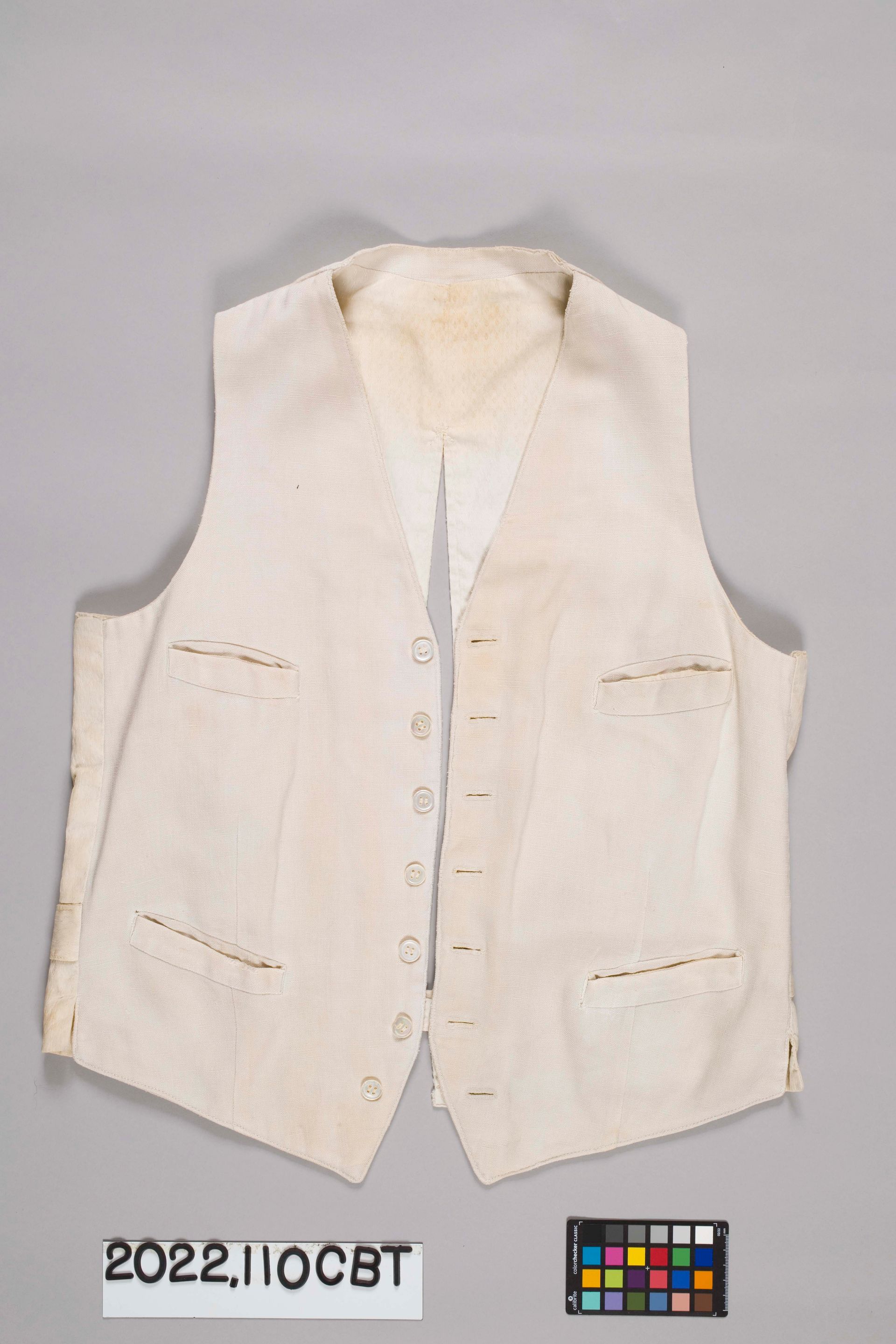 A cream-colored vintage waistcoat with a button-up front, four pockets, and a pointed hem on a neutral background.