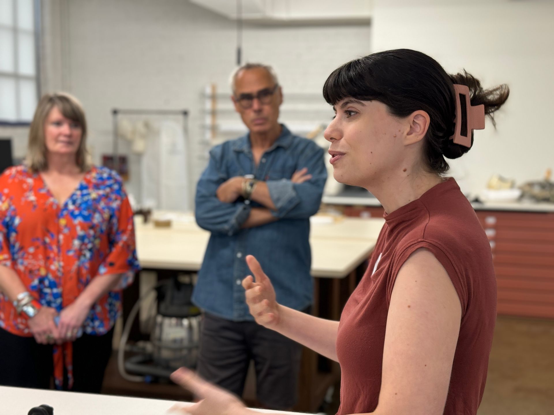 A woman is talking to a group of people in a room.