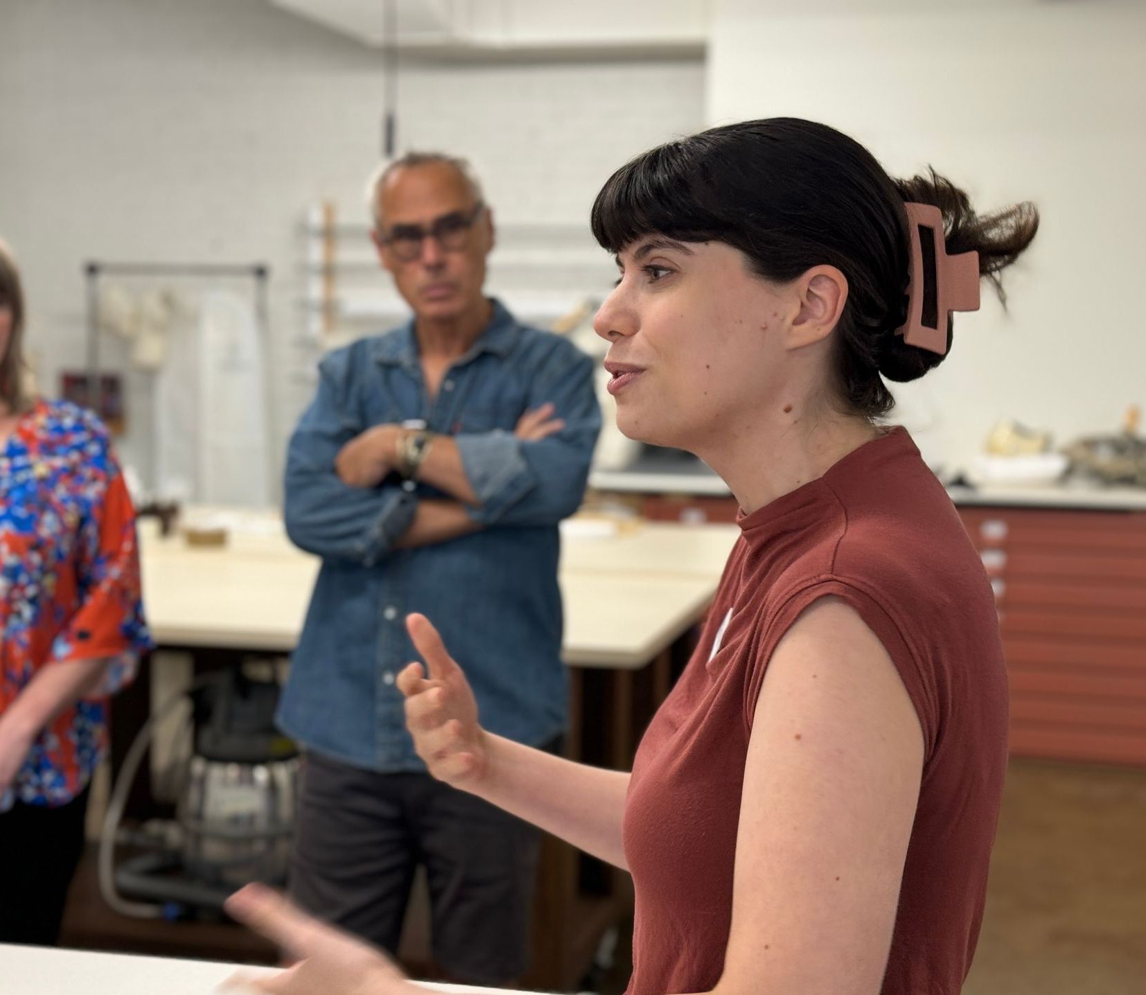 A woman in a red shirt is talking to a group of people