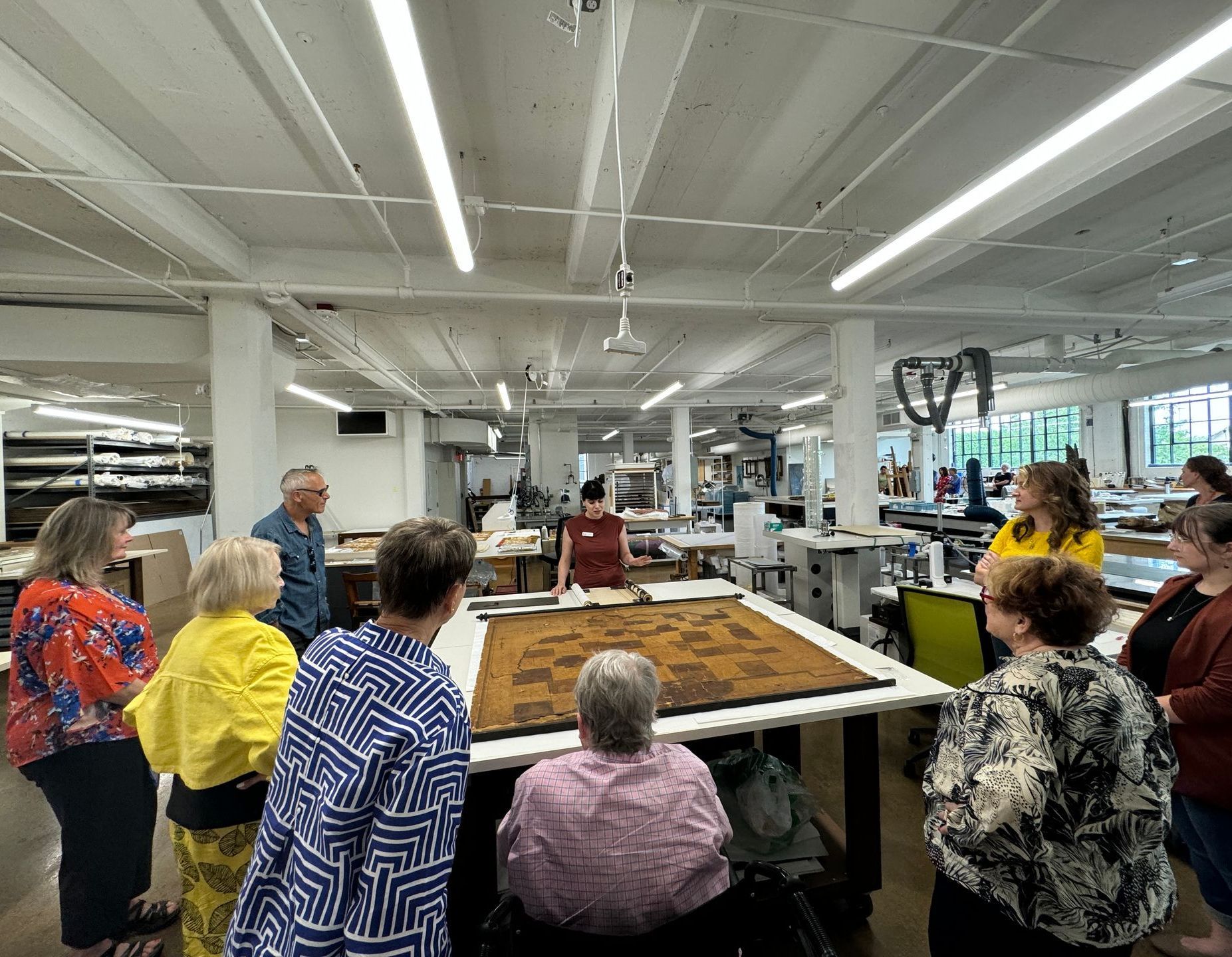 A group of people are standing around a table in a large room.