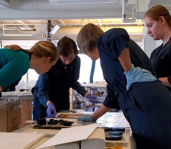 A woman is working on a sculpture in a room.
