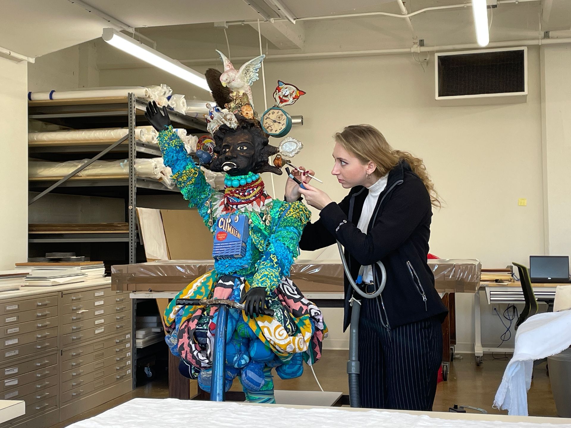 A woman is working on a sculpture in a room.